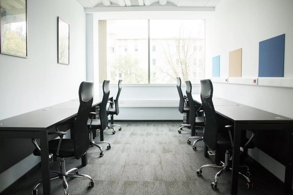 Bright serviced office featuring white desks and ergonomic chairs
