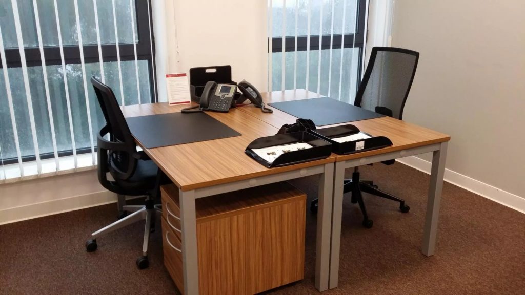 Two desks with chairs inside one of the offices at Regus Fronton